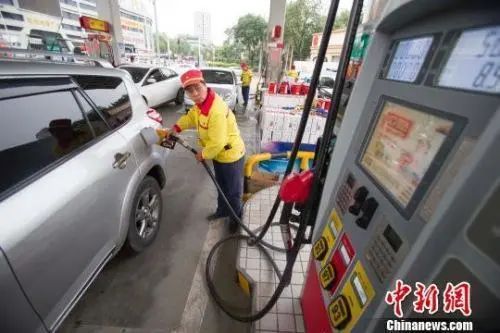 资料图:加油站工作人员正在给车辆加油。 张云 摄